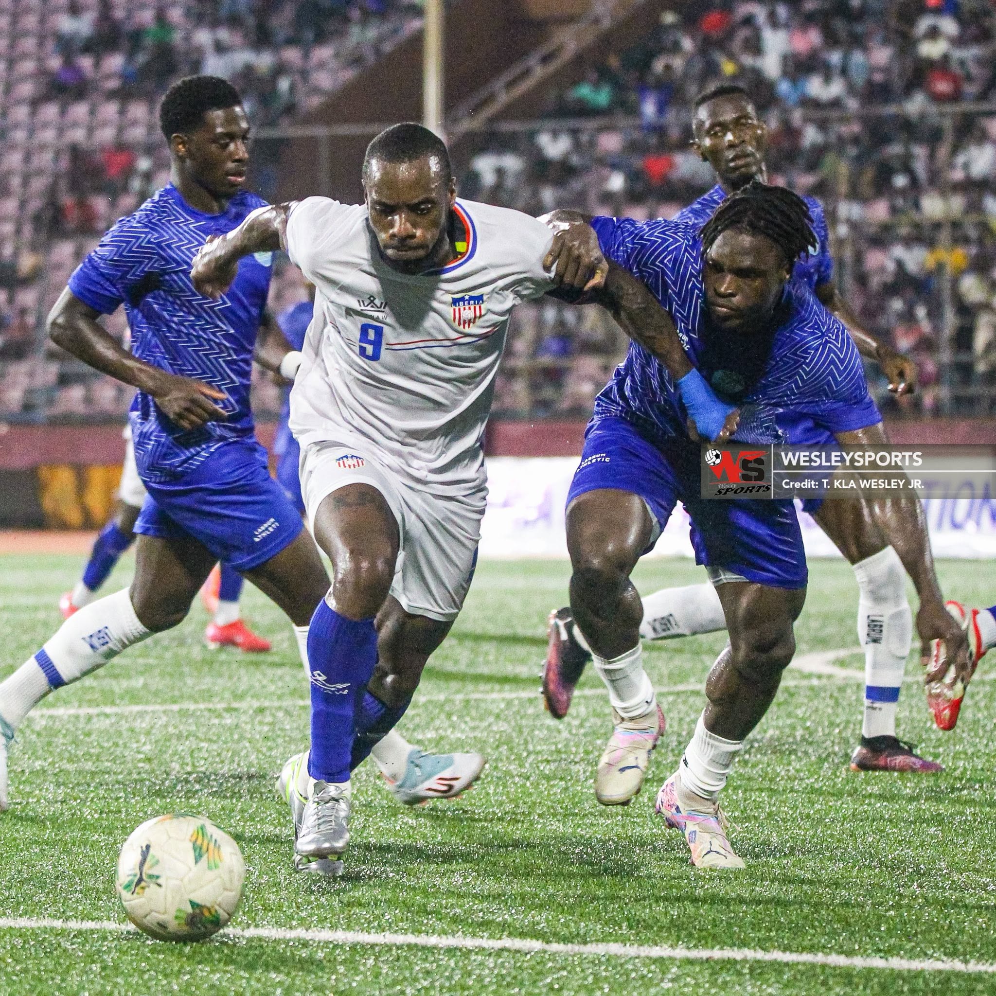 Liberian striker Sherman vies for the ball with Sierra Leone defender Alpha Turay